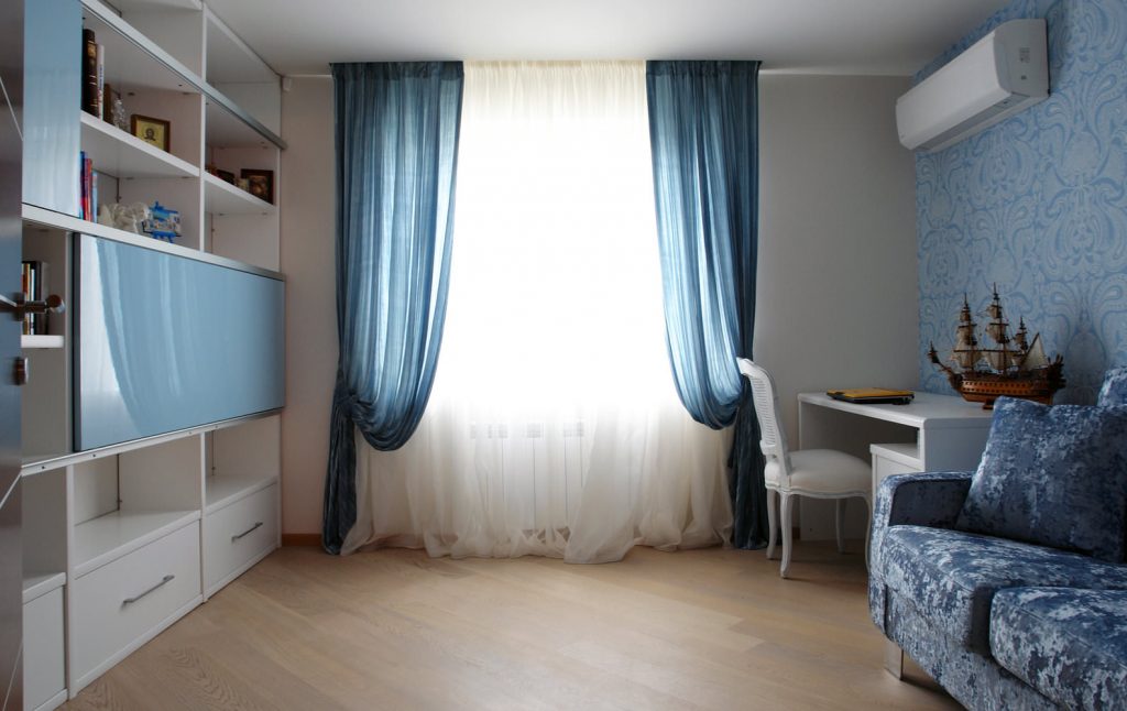Rideaux bleus sur la fenêtre dans la chambre adolescent