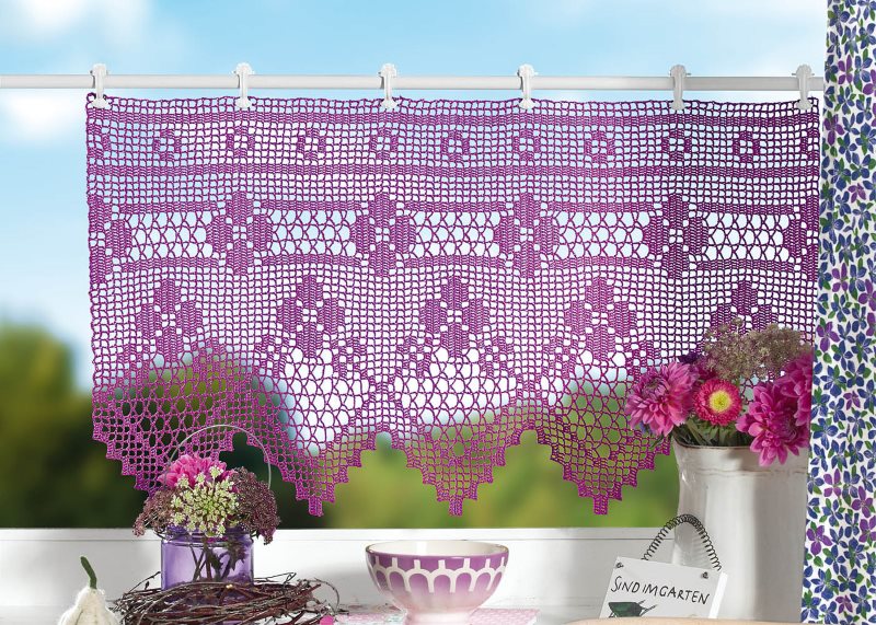 Rideau lilas sur la fenêtre de la cuisine dans une maison rurale