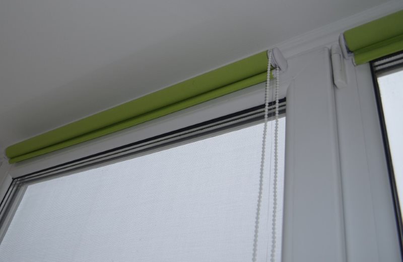 Rideaux enroulés de couleur verte sur une fenêtre en plastique