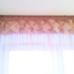 Tulle avec des poufs sur la fenêtre d'un salon moderne